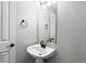 Neutral bathroom with a modern pedestal sink, round towel holder, and a frameless mirror at 1983 Candleglow St, Castle Rock, CO 80109