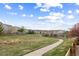 Scenic view of the community showcasing lush green spaces, walking trails, and well-maintained homes under a blue, cloudy sky at 1983 Candleglow St, Castle Rock, CO 80109