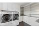 Bright laundry room with modern washer and dryer, ample storage cabinets, and granite countertops at 1983 Candleglow St, Castle Rock, CO 80109