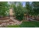 The landscaped backyard features a stone staircase, a lush lawn, and mature landscaping at 510 16Th St, Golden, CO 80401