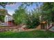 Backyard with trees, shrubs, and a stone retaining wall near the basement access at 510 16Th St, Golden, CO 80401