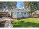Charming backyard with lush lawn and shaded patio with a grill and outdoor furniture at 4190 S Grant St, Englewood, CO 80113