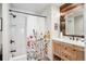 This bathroom features rustic wood, an ornate vanity, and a shower/tub combo at 4190 S Grant St, Englewood, CO 80113