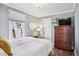This cozy bedroom features a large window, a dresser with a TV, and minimalist decor at 4190 S Grant St, Englewood, CO 80113