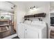 Well-lit laundry room featuring modern machines, storage baskets, and an open archway at 4190 S Grant St, Englewood, CO 80113