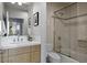 Modern bathroom featuring sleek vanity, large mirror, and glass enclosed tub/shower combination at 1401 Delgany St # 203, Denver, CO 80202