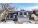 Two-story house with attached garage; nestled in a snow-dusted neighborhood at 8946 W Teton Cir, Littleton, CO 80128