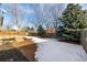 Backyard with partially snow-covered ground and wooden fence at 8946 W Teton Cir, Littleton, CO 80128