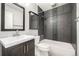 Updated bathroom with gray tile and a tub shower at 8946 W Teton Cir, Littleton, CO 80128