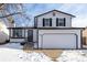 Two-story house with white siding, a two-car garage, and a snow-covered front yard at 8946 W Teton Cir, Littleton, CO 80128