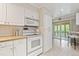 Modern kitchen featuring white cabinetry, granite countertops, and access to the screened in patio at 5751 E Ithaca Pl # 3, Denver, CO 80237