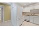 A white kitchen with matching appliances, tiled floor and backsplash, and views of the other rooms at 5751 E Ithaca Pl # 3, Denver, CO 80237