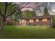 Backyard featuring lush lawn, mature trees, and a patio with a dining set, ideal for outdoor gatherings at 7034 S Cherry St, Centennial, CO 80122