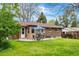 Brick home backyard patio with outdoor dining set and lush lawn, perfect for relaxing and entertaining at 7034 S Cherry St, Centennial, CO 80122