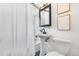Compact bathroom featuring a pedestal sink, toilet, and shower-tub with white tile at 7034 S Cherry St, Centennial, CO 80122