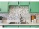 Close-up of kitchen sink and stylish stone tile backsplash in a home's kitchen at 7034 S Cherry St, Centennial, CO 80122