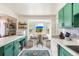 Kitchen area featuring a breakfast nook, green cabinets, and view of the backyard at 7034 S Cherry St, Centennial, CO 80122