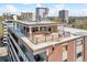 Stunning aerial view of a building featuring a rooftop terrace with outdoor dining and lounge areas at 1085 N Lafayette St # 702, Denver, CO 80218