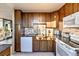 Modern kitchen with stainless appliances, wood cabinets, and adjacent outdoor balcony at 1085 N Lafayette St # 702, Denver, CO 80218