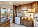 Well-lit kitchen boasts wood cabinets, stainless appliances, and access to a balcony with city views at 1085 N Lafayette St # 702, Denver, CO 80218