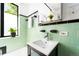 Bright bathroom with a modern vanity, green tile, and a sunny window at 1160 Birch St # 22, Denver, CO 80220