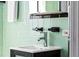 Retro-style bathroom with mint green tile, vanity and modern chrome faucet at 1160 Birch St # 22, Denver, CO 80220