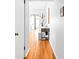 Long hallway with hardwood floors, white trim, and functional decor with a small desk at 1160 Birch St # 22, Denver, CO 80220