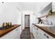 Galley kitchen with white cabinets, wood counters, and patterned tile floors at 1160 Birch St # 22, Denver, CO 80220