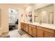 Bright bathroom with dual sinks, modern fixtures, and a view into the primary bedroom at 3492 N Buchanan Way, Aurora, CO 80019