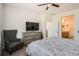 Relaxing bedroom view with a chair, dresser, TV, and access to an ensuite bathroom at 3492 N Buchanan Way, Aurora, CO 80019