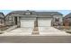 View of the exterior featuring stone accents and attached garages on a sunny day at 3492 N Buchanan Way, Aurora, CO 80019