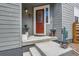 Cozy front porch with a red door, decorative plants, and stylish exterior lighting at 3492 N Buchanan Way, Aurora, CO 80019