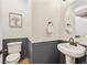 Charming powder room with wainscoting, a pedestal sink, a round mirror, and a framed floral picture at 684 Poppy Pl, Highlands Ranch, CO 80129