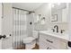 Renovated bathroom with a white vanity, black hardware, and tiled shower at 684 Poppy Pl, Highlands Ranch, CO 80129