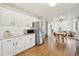 Open-concept kitchen with white cabinets and stainless steel appliances flows into the dining and living areas at 684 Poppy Pl, Highlands Ranch, CO 80129