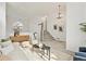 Bright, open-concept living area with high ceilings, modern décor, and staircase access at 684 Poppy Pl, Highlands Ranch, CO 80129