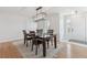 Cozy dining area features a modern light fixture, hardwood floors, and seating for six at 10885 Longs Peak Ln, Parker, CO 80138