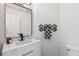 Stylish half bath with a modern vanity, decorative mirror, and towel hanger at 10885 Longs Peak Ln, Parker, CO 80138