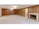 Spacious finished basement with brick fireplace, wood paneling and neutral carpeting at 3375 Zephyr Ct, Wheat Ridge, CO 80033