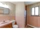 Small bathroom with a shower, single sink vanity and retro pink tile at 3375 Zephyr Ct, Wheat Ridge, CO 80033
