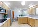 Bright kitchen with stainless steel appliances, light wood cabinets, and views into the breakfast nook at 3375 Zephyr Ct, Wheat Ridge, CO 80033