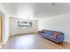 Bright living room with hardwood floors and a gray couch near a large window with outside views at 3375 Zephyr Ct, Wheat Ridge, CO 80033