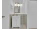 White vanity, mirror, and modern lighting fixtures in tiled bathroom at 14467 E 1St Dr # A04, Aurora, CO 80011