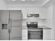 Modern kitchen featuring stainless steel appliances, white cabinets, and gray countertops at 14467 E 1St Dr # A04, Aurora, CO 80011