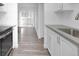Kitchen featuring stainless steel sink, white cabinets, and views to the living area at 14467 E 1St Dr # A04, Aurora, CO 80011
