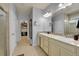 A bright bathroom with double sinks, large mirror, tile flooring, and a walk-in closet at 675 W 171St Pl, Broomfield, CO 80023