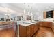 Spacious kitchen with a large island, wooden cabinets, hardwood floors, and views into the dining room at 4577 Elm Ct, Denver, CO 80211