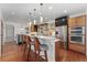 Modern kitchen featuring stainless steel appliances, breakfast bar, and hardwood floors at 4577 Elm Ct, Denver, CO 80211