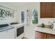 Well-lit laundry room with modern washer and dryer and granite countertops at 4577 Elm Ct, Denver, CO 80211