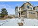 Townhome exterior, featuring a two-car garage and snowy front yard at 5445 Canyon View Dr, Castle Rock, CO 80104